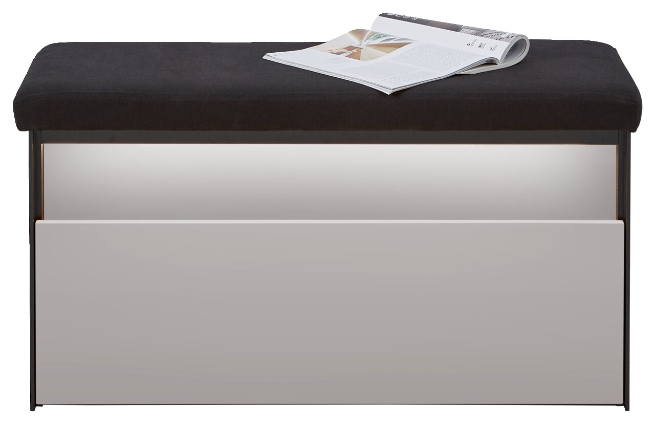 Garderobenbank mit schwarzer Sitzfläche und weißer Frontansicht, darauf liegt eine geöffnete Zeitschrift.