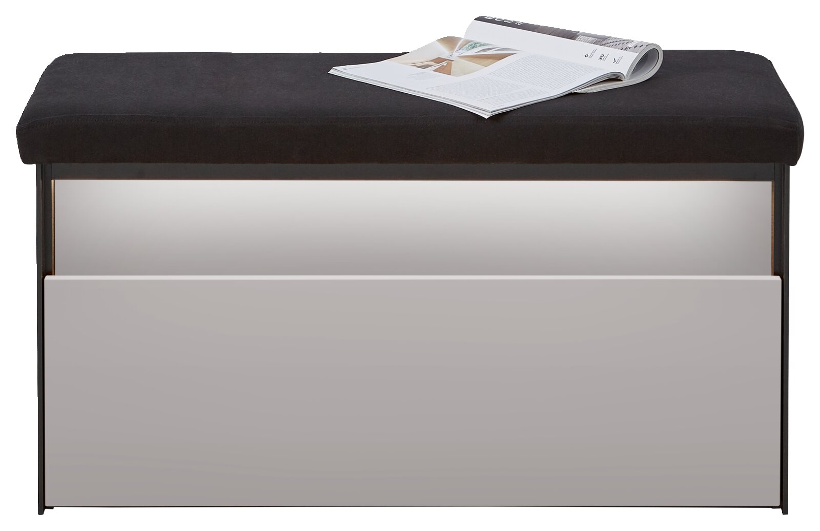 Een kaptafel met een zwarte zitting en een witte voorkant, waarop een open tijdschrift ligt.