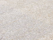 Nahaufnahme eines weichen, cremefarbenen Teppichs mit flauschiger Textur, perspektivisch von oben betrachtet.