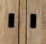 Nahaufnahme von zwei schwarzen Griffen auf einer Holzoberfläche eines Sideboards, Frontansicht.