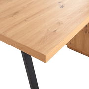 Nahaufnahme eines Schreibtisches mit Holzoberfläche und schwarzen Metallbeinen, Perspektive von oben.