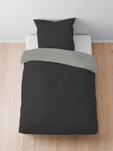 Bettwäsche-Set aus Melange-Flanell in Dunkelgrau, bestehend aus einem Kissenbezug und einem Bettdeckenbezug, auf einem Bett von oben fotografiert.