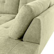 Nahaufnahme einer grünen Sofaecke mit Ottomane links, Perspektive von oben.