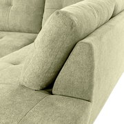 Nahaufnahme einer grünen Sofaecke mit Ottomane links, Perspektive von oben.