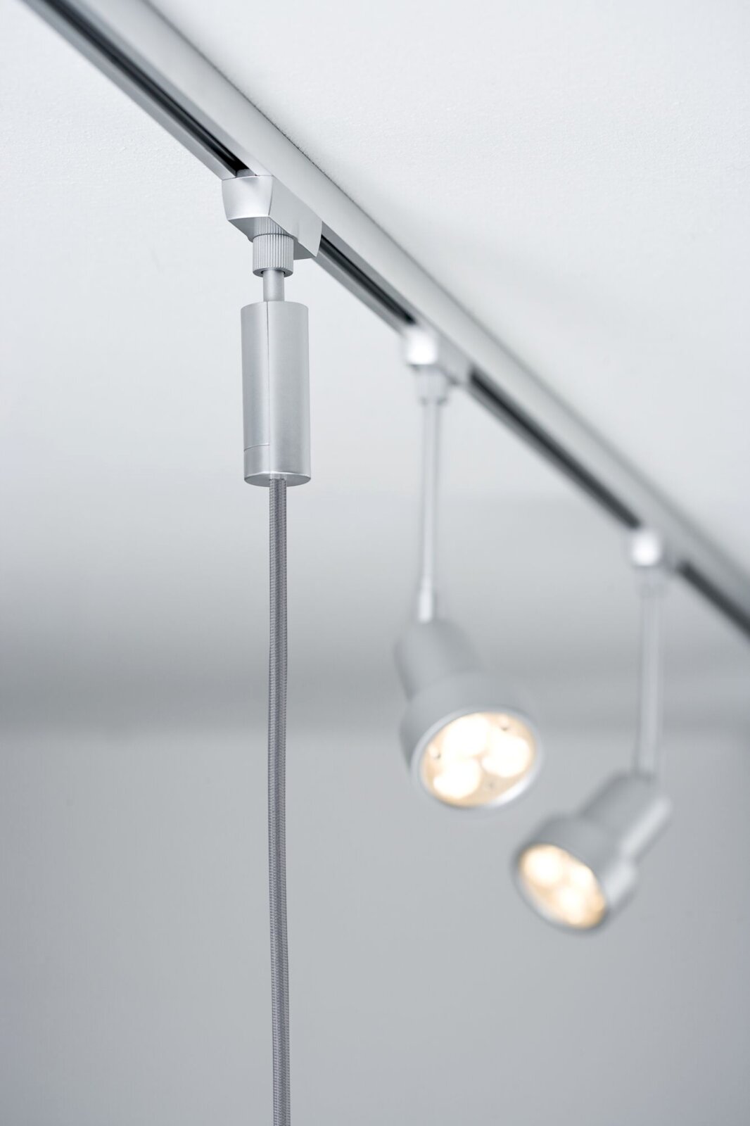 Silbernes Basispendel an einer Deckenleiste mit zwei LED-Lampen, seitliche Perspektive
