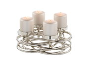 Moderner, silberner Kerzenhalter mit vier brennenden Kerzen, aus einer leicht erhöhten Perspektive fotografiert.