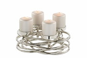 Moderner, silberner Kerzenhalter mit vier brennenden Kerzen, aus einer leicht erhöhten Perspektive fotografiert.