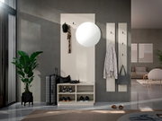 Moderne weiße Garderobe im Flur mit Schuhbank und offenen Fächern, Wandpaneel mit Haken und rundem Spiegel sowie zwei schmalen Hakenleisten, fotografiert frontal in leichter Seitenperspektive.