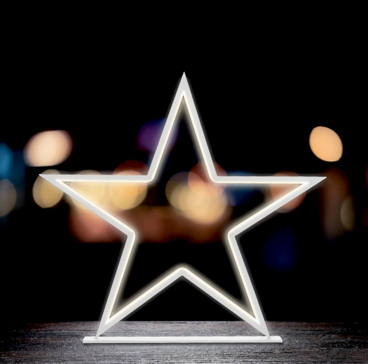 LED-Stern in Sternform, leuchtend auf einem Tisch vor unscharfem Hintergrund, frontal betrachtet