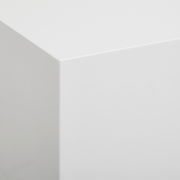 Nahaufnahme einer weißen, glatten Ecke eines Lowboards aus der Perspektive von oben.