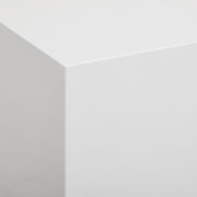 Nahaufnahme einer weißen, glatten Ecke eines Lowboards aus der Perspektive von oben.