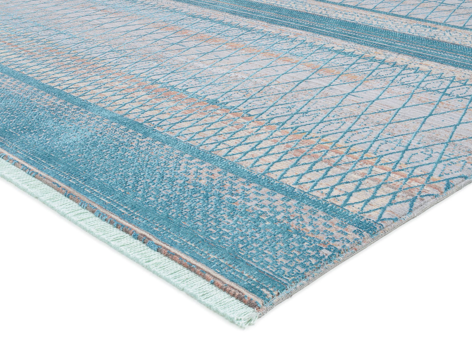 Designer Teppich in Blau- und Beigetönen mit geometrischem Muster, perspektivisch von der Seite fotografiert.