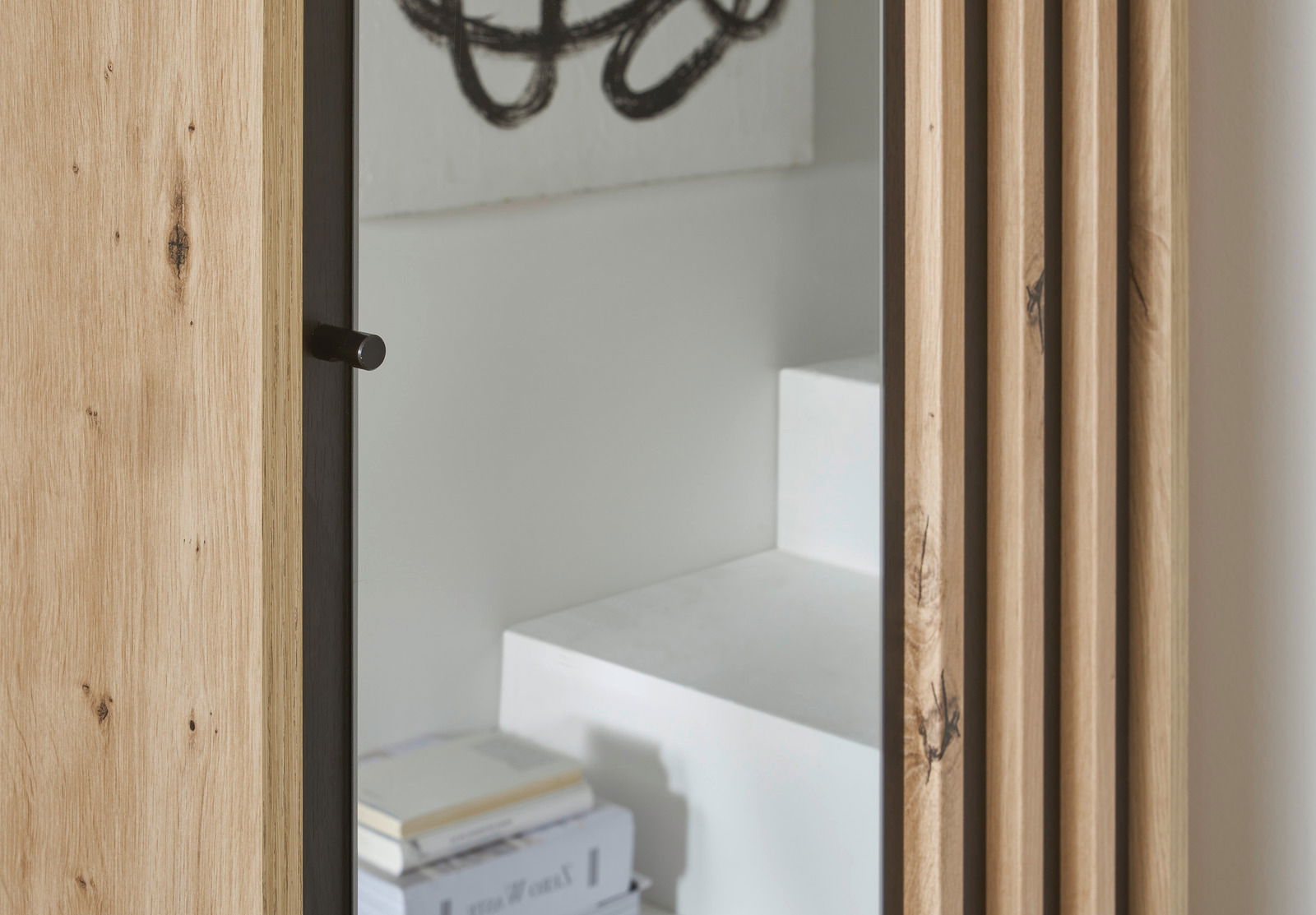 Detailansicht einer Kompakt-Garderobe mit Holzverkleidung und Spiegel, seitliche Perspektive.