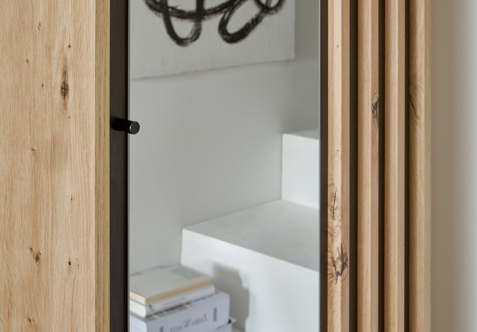 Detailansicht einer Kompakt-Garderobe mit Holzverkleidung und Spiegel, seitliche Perspektive.