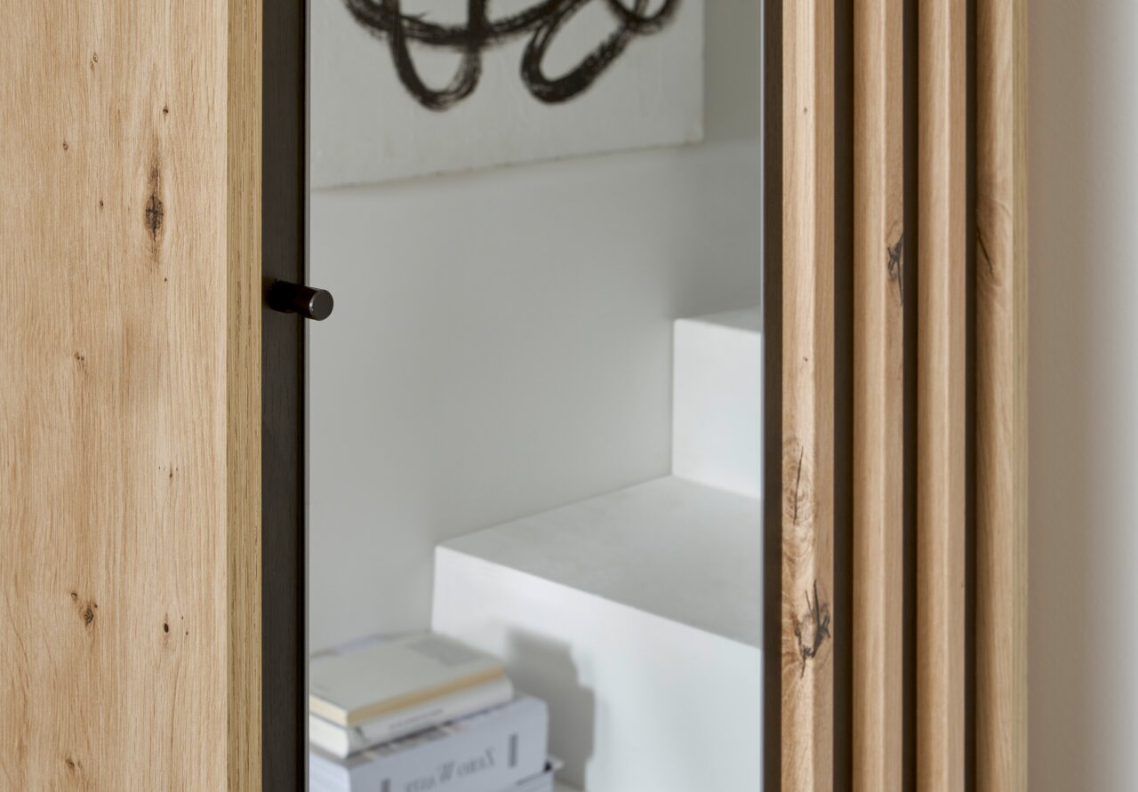 Detailansicht einer Kompakt-Garderobe mit Holzverkleidung und Spiegel, seitliche Perspektive.