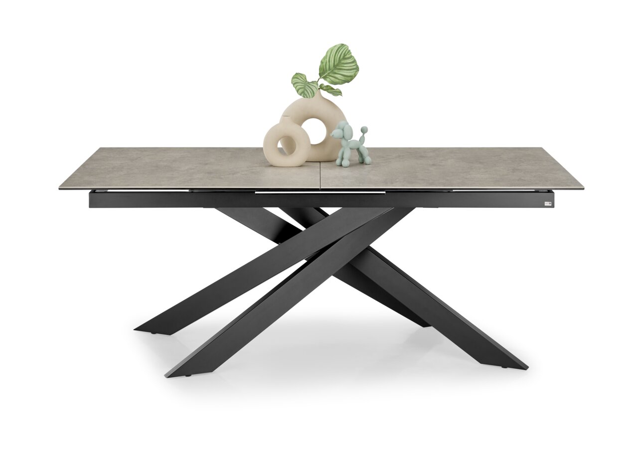 Moderner Esstisch mit grauer Tischplatte und schwarzem, gekreuztem Metallgestell, seitliche Perspektive