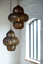 Zwei orientalische Hängeleuchten aus Metall mit filigranem Muster, seitliche Perspektive, im Hintergrund ein Fenster.
