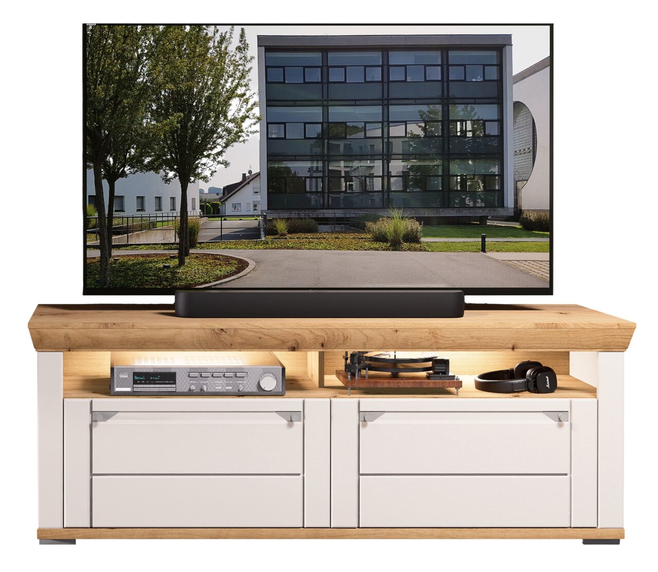 TV-Lowboard aus Holz mit weißem Korpus und zwei Schubladen, darauf ein großer Flachbildfernseher. Frontale Perspektive.
