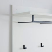 Garderobenpaneel in seitlicher Perspektive mit weißem Regalbrett und schwarzen Haken.