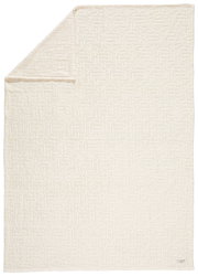 Weißes Plaid mit geprägtem Muster, ausgebreitet und von oben fotografiert.