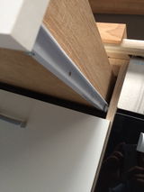 Nahaufnahme eines Küchenschranks mit Holz- und weißen Elementen, seitliche Perspektive