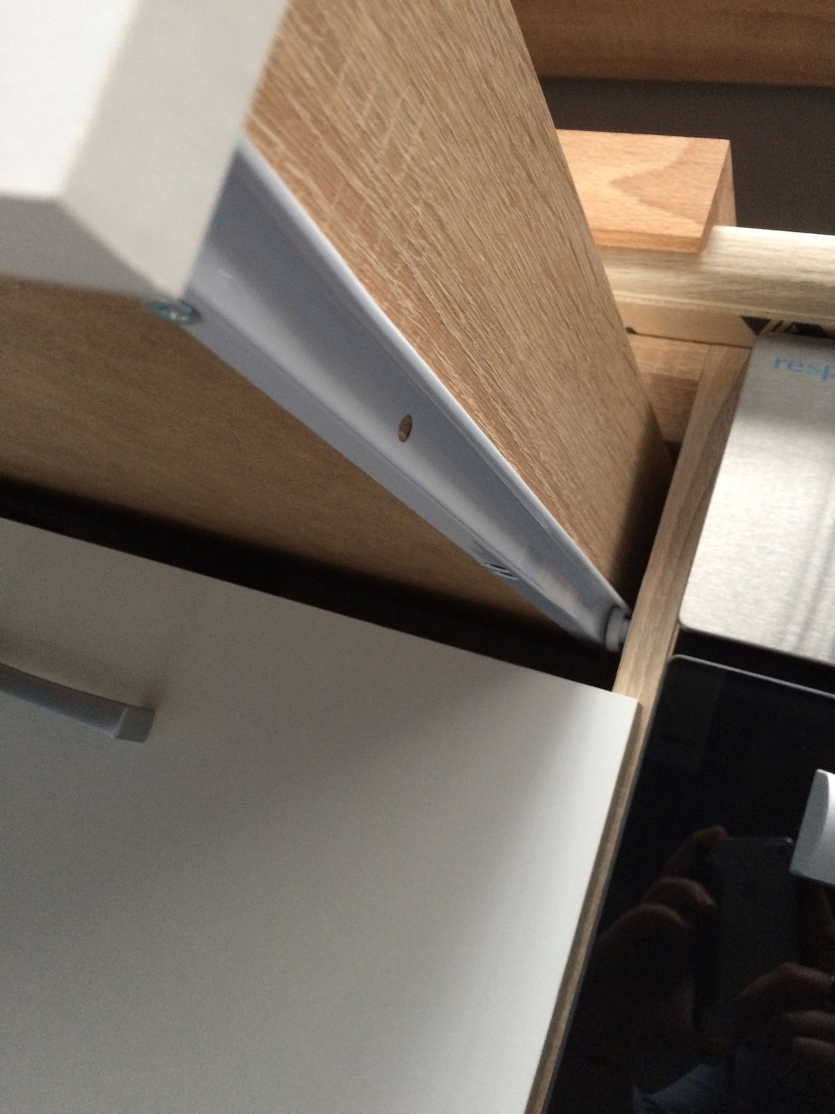 Nahaufnahme eines Küchenschranks mit Holz- und weißen Elementen, seitliche Perspektive