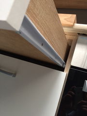 Nahaufnahme eines Küchenschranks mit Holz- und weißen Elementen, seitliche Perspektive