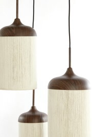 Drie moderne hanglampen met een donkerbruine houtlook en een cilindervormige, crèmekleurige stoffen kap, hangend tegen een witte achtergrond; close-up vanuit een licht zijdelings perspectief