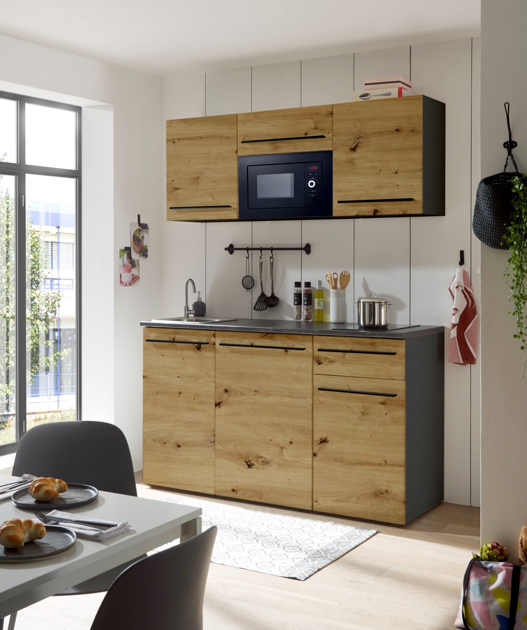 Moderne Single-Küche 160 mit Holzfronten, eingebauter Mikrowelle und Spüle, seitliche Perspektive