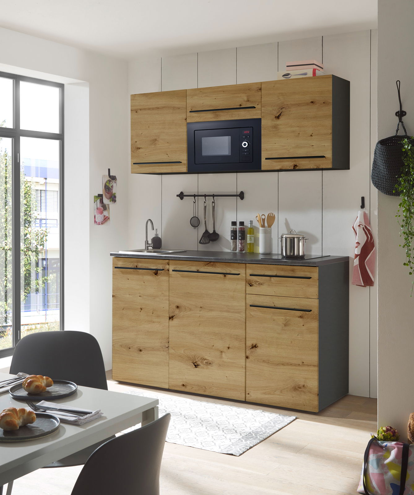 Moderne Single-Küche 160 mit Holzfronten, eingebauter Mikrowelle und Spüle, seitliche Perspektive