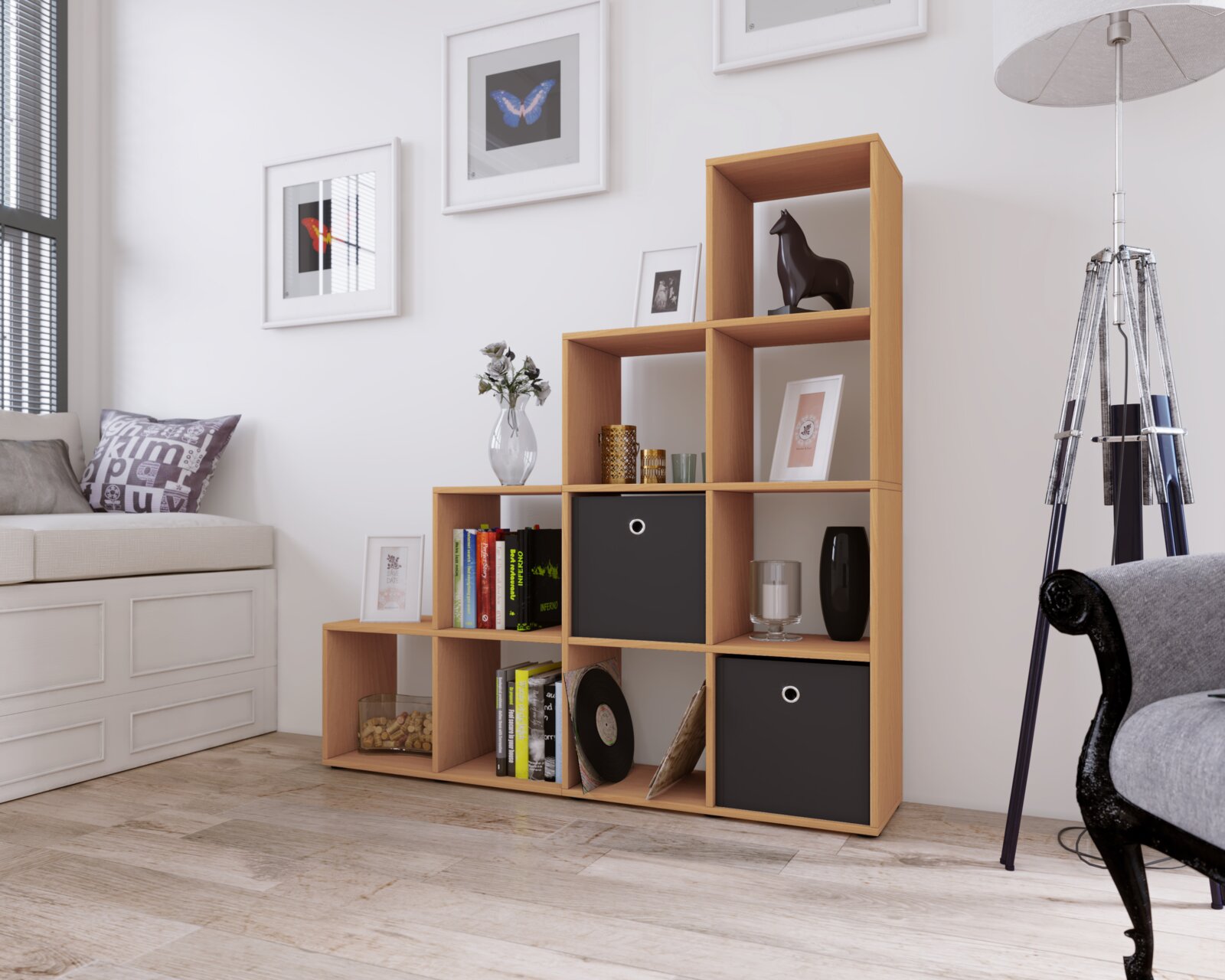 Modernes, asymmetrisches Würfelregal aus hellem Holz mit schwarzen Stoffboxen, dekoriert mit Büchern und Vasen, in einem hellen Wohnzimmer Perspektive: frontale Ansicht leicht von links.