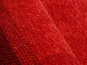 Nahaufnahme eines roten Wollteppichs mit feiner Textur und diagonaler Perspektive