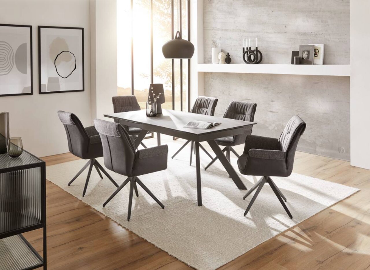 Moderne eettafel met zes gestoffeerde stoelen in een stijlvolle eetkamer, gezien vanaf de zijkant.