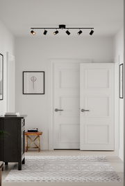 Deckenstrahler mit fünf schwarzen Spots in einem modernen, hellen Raum, Perspektive von unten