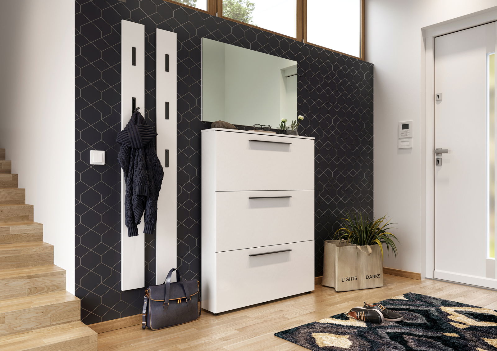 Moderner weißer Schuhschrank mit drei Schubladen, platziert in einem stilvollen Eingangsbereich mit dunkler geometrischer Tapete und einem großen Spiegel darüber. Perspektive von vorne.