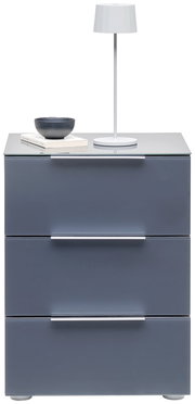 Moderne Nachtkonsole mit drei Schubladen in grauer Farbe, darauf eine weiße Tischlampe, eine Schale und Bücher. Frontalansicht.