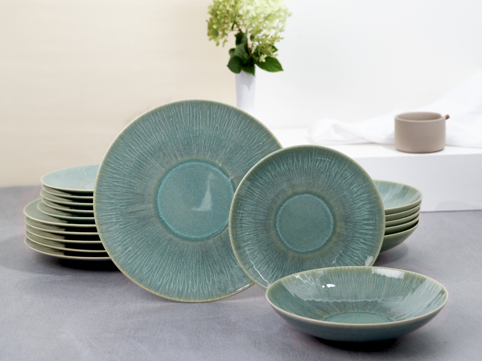 Creatable Tellerset 18-tlg SEA BREEZE Grün-blaues Keramik-Geschirrset mit strukturierten Tellern und Schale, frontal in leichter Seitenperspektive auf einem Tisch arrangiert