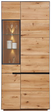 Frontansicht der Vitrine KELIO aus Holz mit Glaseinsatz und Beleuchtung, zeigt Gläser und Dekoration.