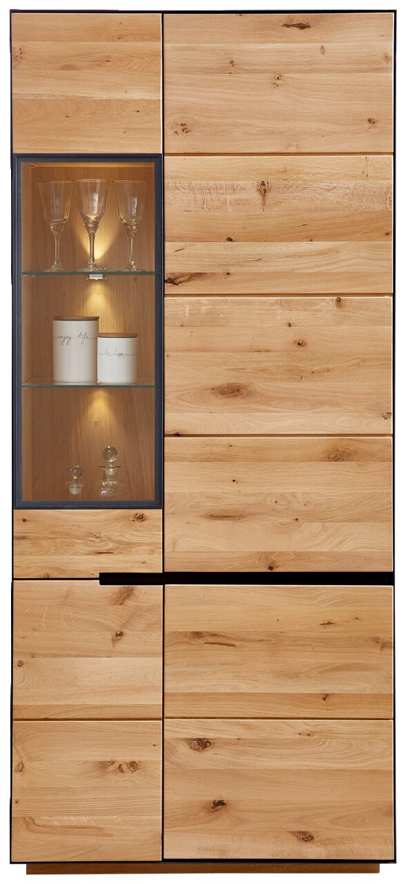 Vooraanzicht van de houten vitrinekast KELIO met glazen inzetstuk en verlichting, met glazen en decoratie.
