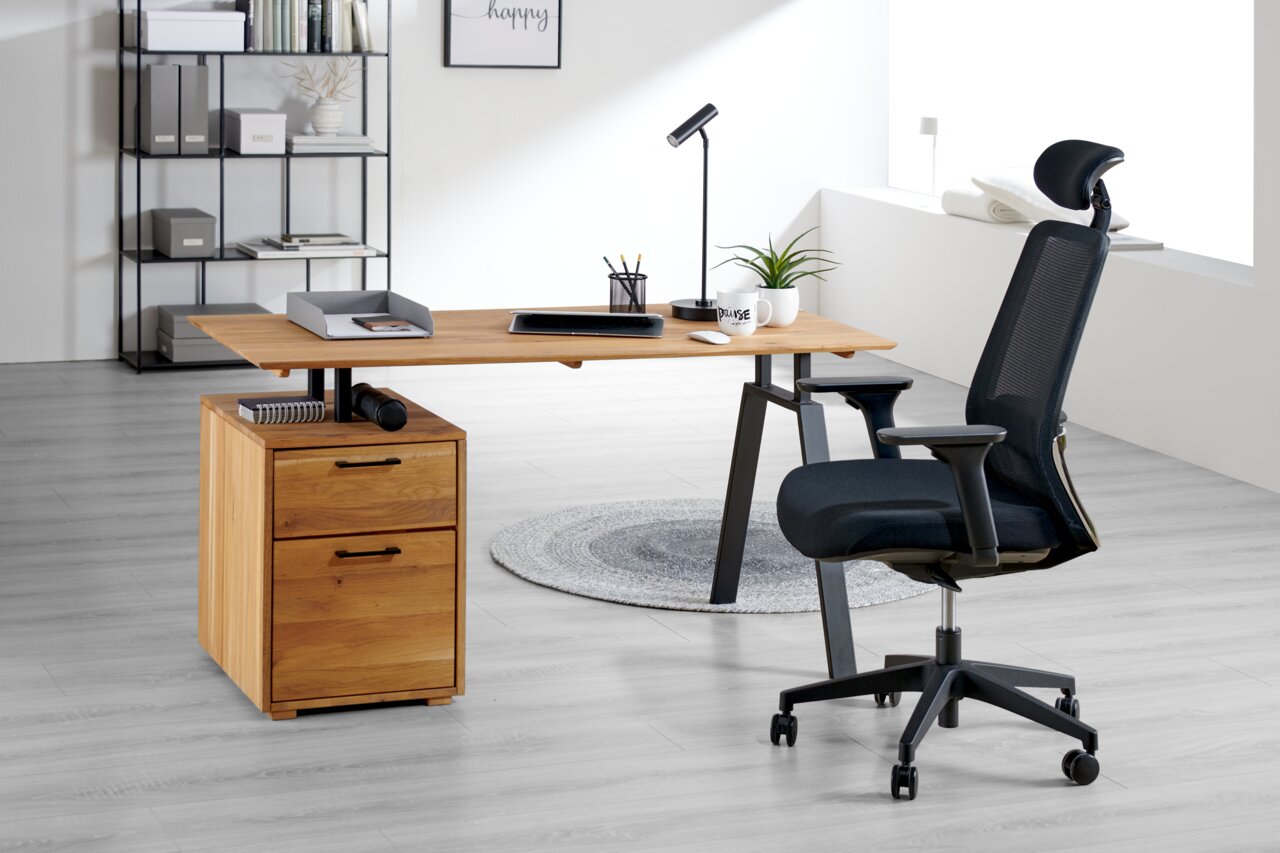Novel Drehstuhl BJARNE Moderner Drehstuhl in einem hellen Büro, seitliche Perspektive, neben einem Schreibtisch aus Holz mit Schubladen und Büromaterial.