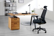 Moderner Drehstuhl in einem hellen Büro, seitliche Perspektive, neben einem Schreibtisch aus Holz mit Schubladen und Büromaterial.