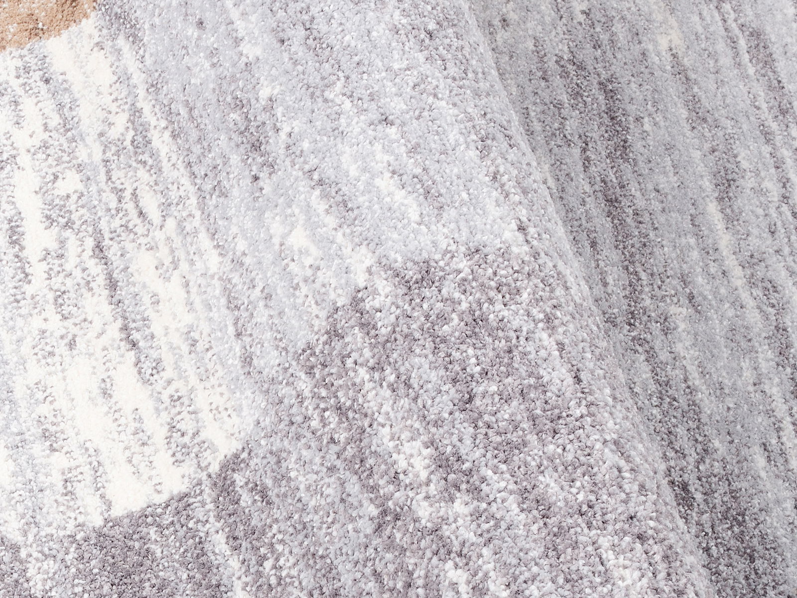 Nahaufnahme eines grauen und weißen Frisé-Teppichs mit weicher Textur und leichtem Farbverlauf.