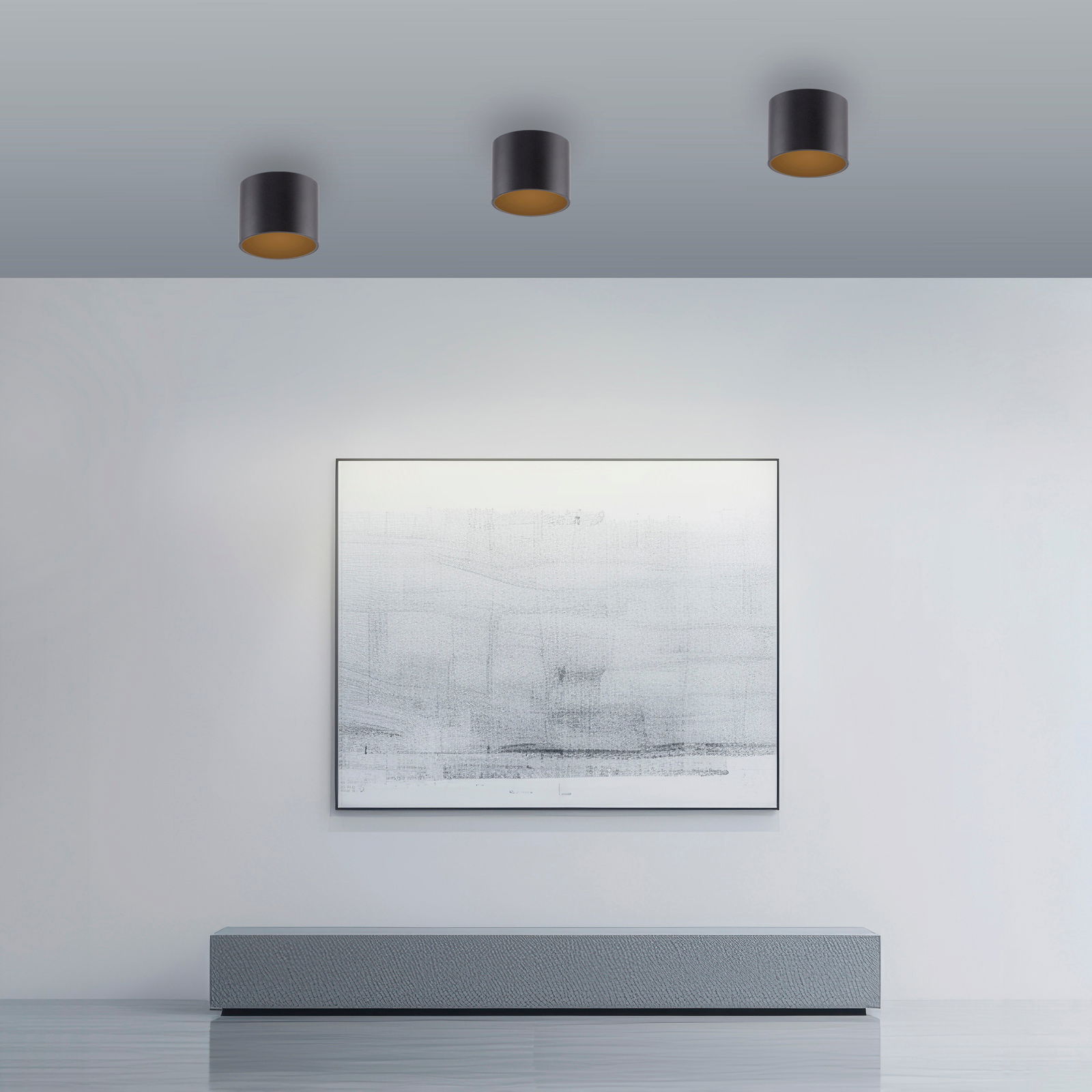 Drei schwarze LED-Deckenleuchten PURE POINT von Neuhaus, montiert an einer grauen Decke, beleuchten einen modernen Raum mit einem großen abstrakten Kunstwerk an der Wand. Perspektive von unten.