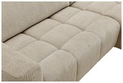 Nahaufnahme eines beigen Ecksofas mit gepolsterten Sitzflächen, seitliche Perspektive.