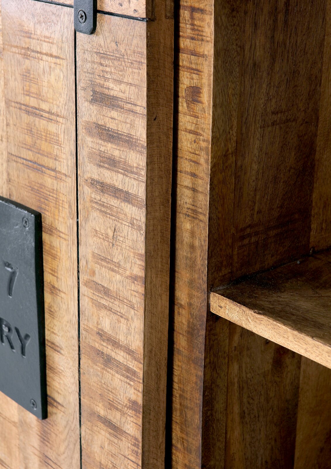Nahaufnahme eines rustikalen Highboards aus Holz mit Metallbeschlägen, seitliche Perspektive.