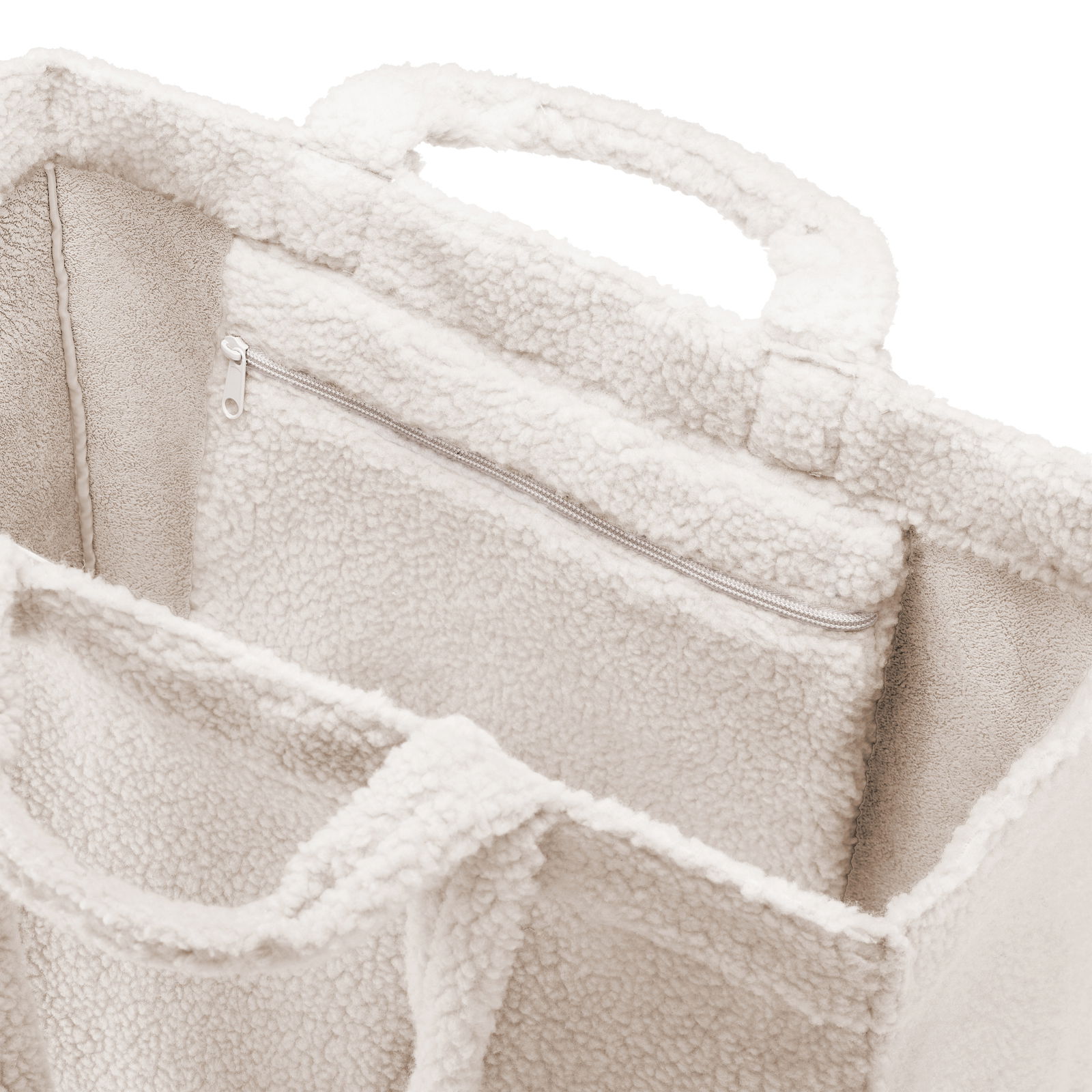 Nahaufnahme einer weichen, cremefarbenen Tasche mit Reißverschluss und Tragegriffen, von oben betrachtet.