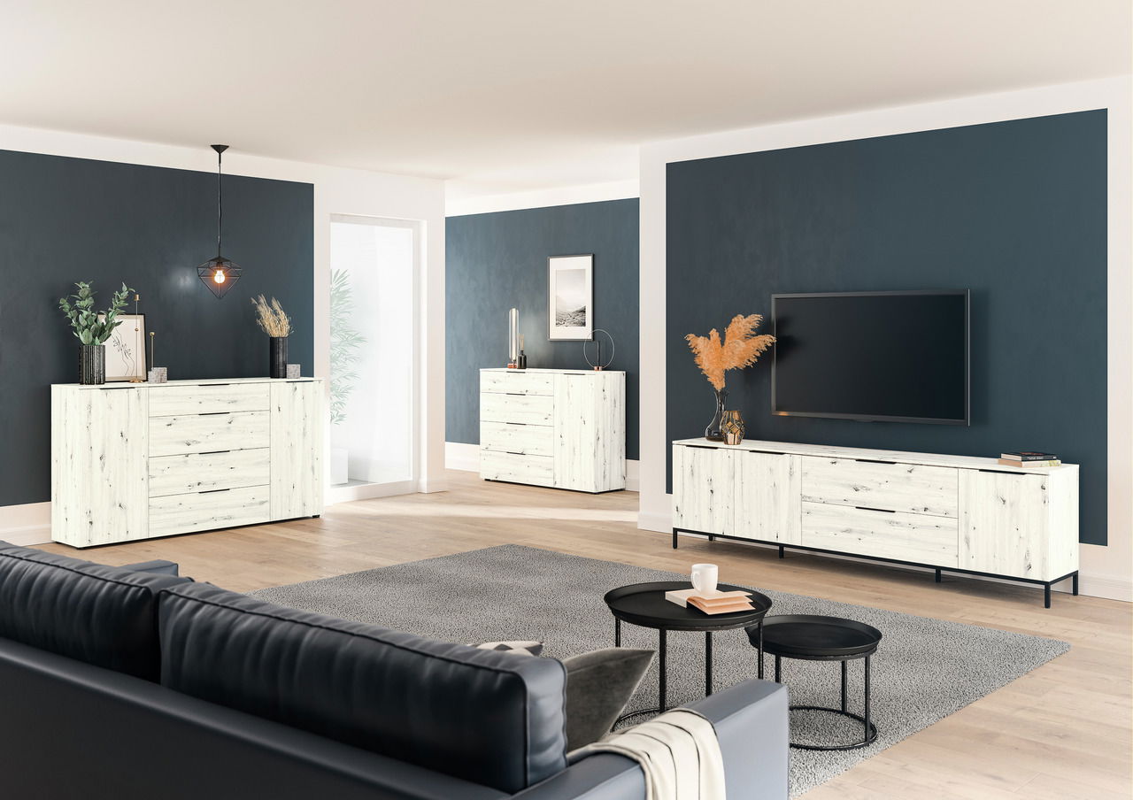 Moderne Wohnzimmermöbel in heller Holzoptik, bestehend aus einem TV-Lowboard, einer Kombikommode und einer Schubkastenkommode, in einem stilvoll eingerichteten Raum mit dunklen Wänden und Holzboden. Perspektive von der Seite.