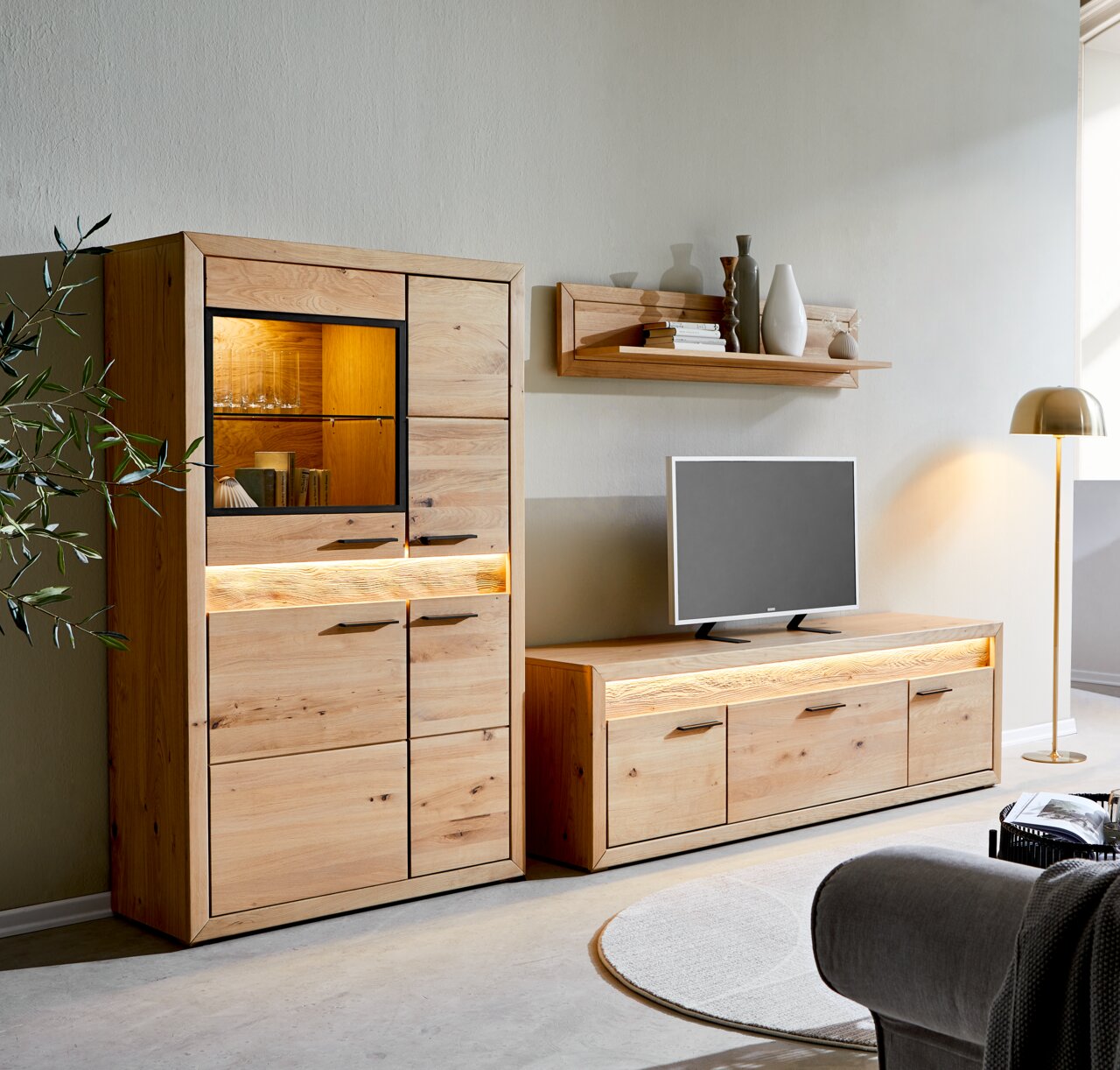 Modernes Lowboard aus Holz mit integrierter Beleuchtung, frontal fotografiert, neben einem passenden Schrank und unter einem Wandregal.