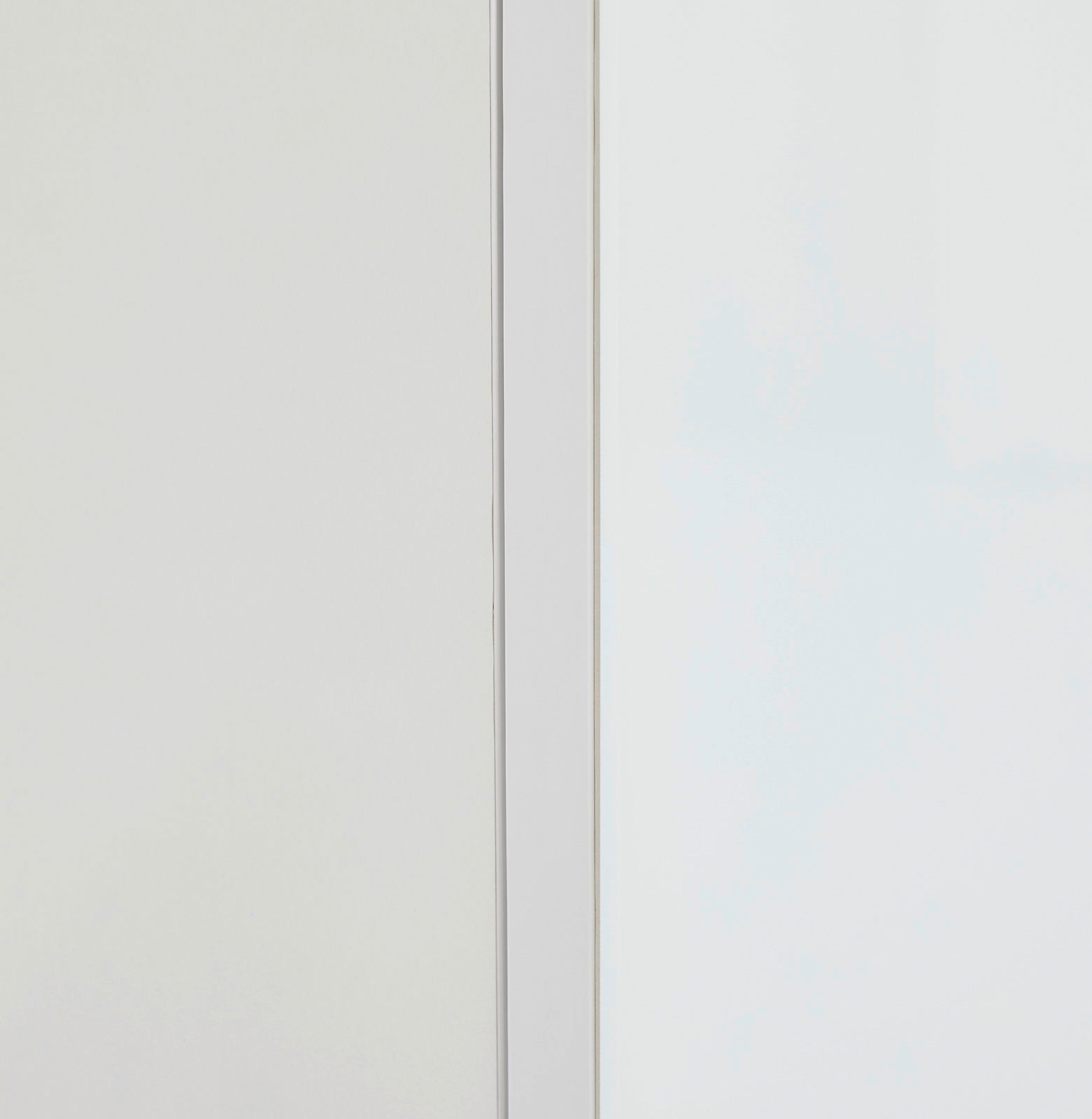 Nahaufnahme eines weißen Aufsatzschranks mit klaren Linien und minimalistischer Gestaltung, seitliche Perspektive.