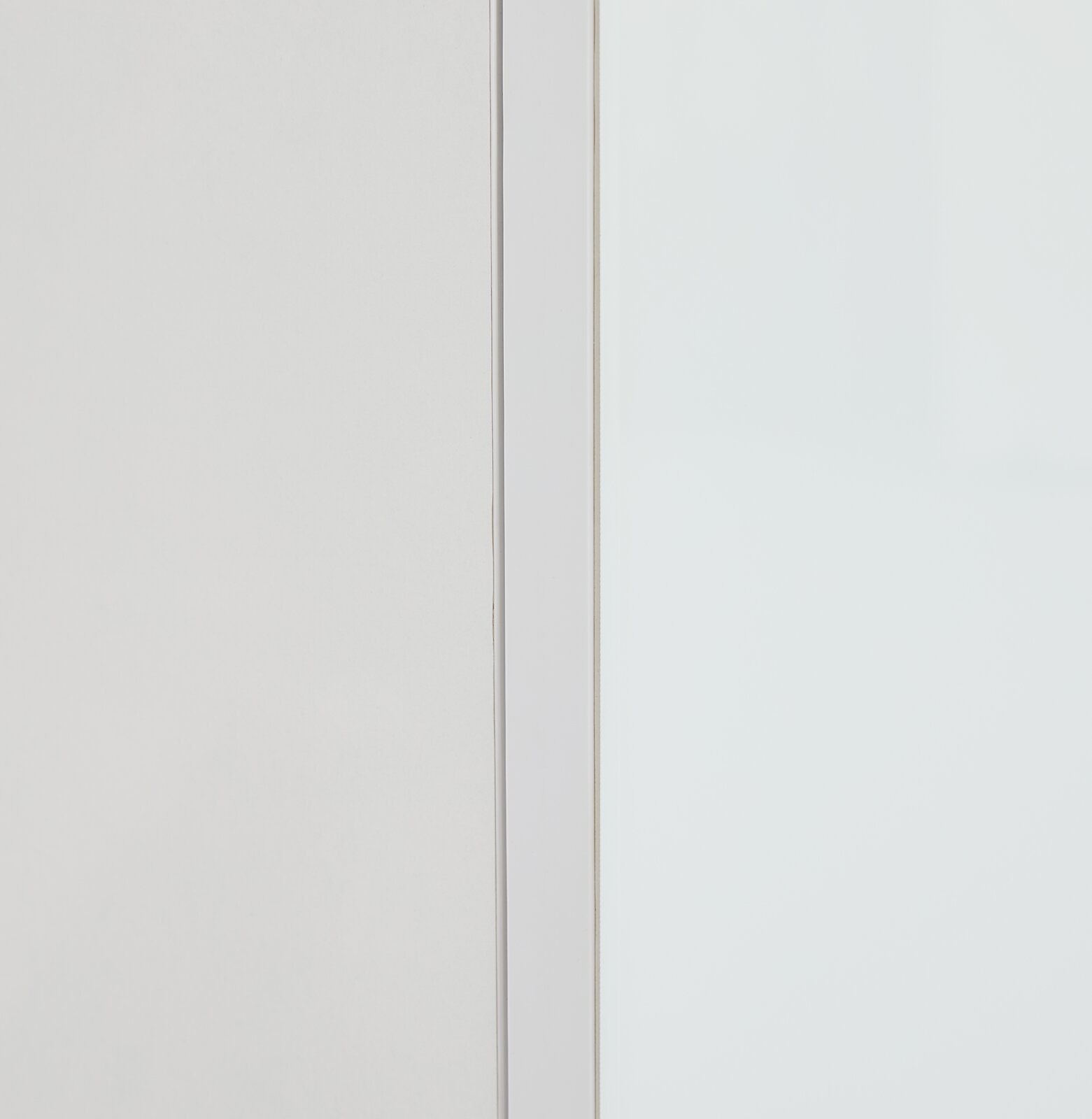 Nahaufnahme eines weißen Aufsatzschranks mit klaren Linien und minimalistischer Gestaltung, seitliche Perspektive.